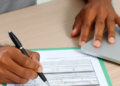 A man filling out an hsa application form at his desk
