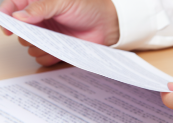 A person scrutinizing a document, possibly about health insurance